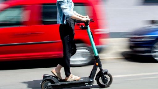 Foto: Eine Frau auf einem E-Scooter (picture alliance/dpa | Hauke-Christian Dittrich)